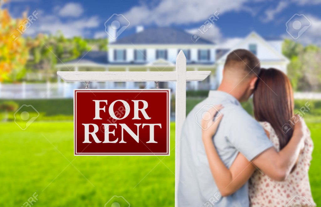 For Rent Real Estate Sign and Affectionate Military Couple Looking at Nice New House.